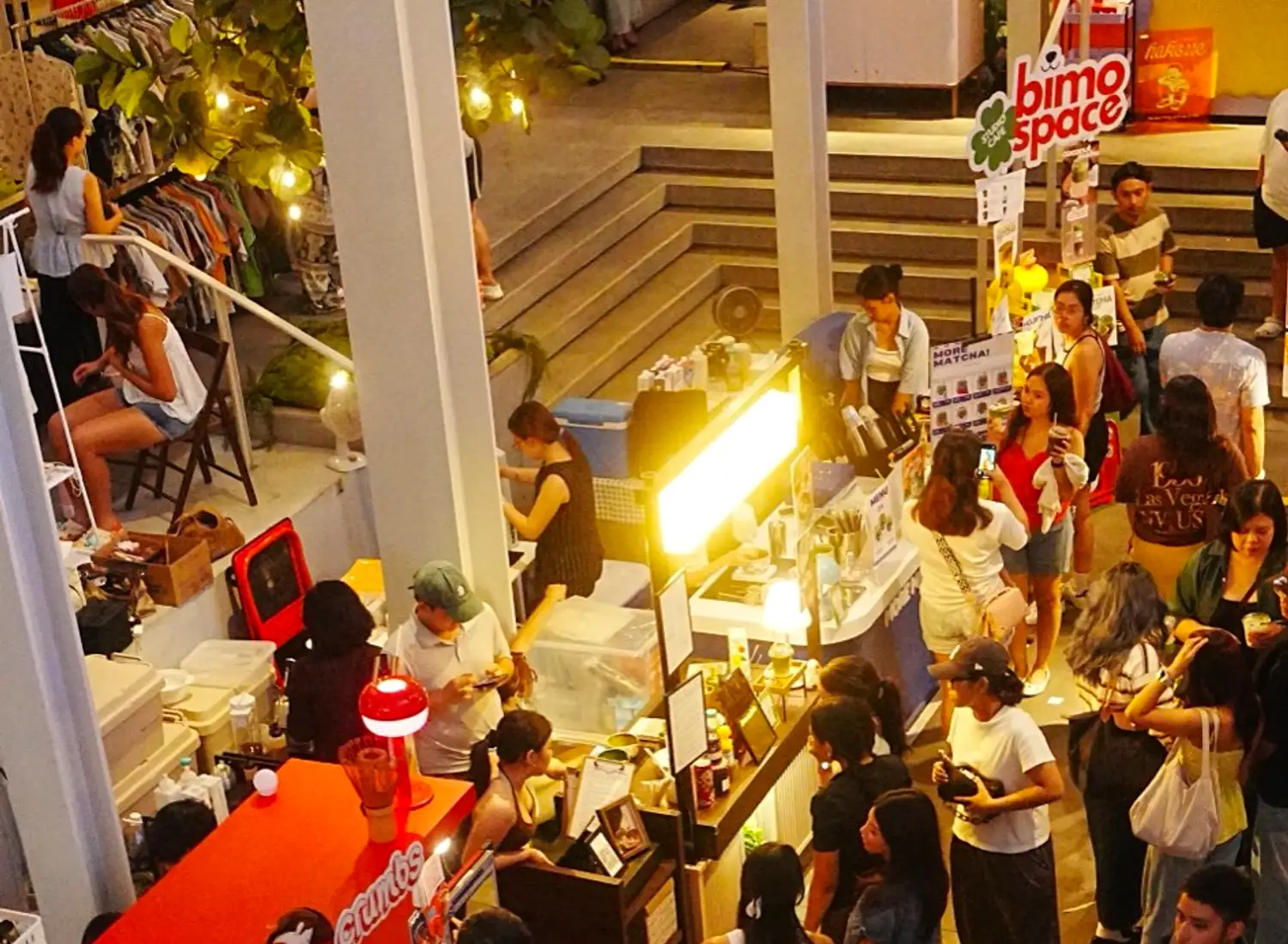 Overhead view of a Cabana Club pop-up floor, vendor booths and crowd under string lights